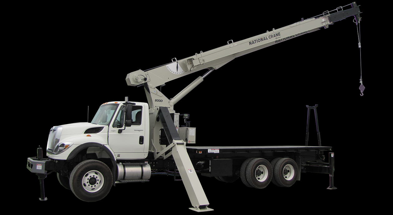 A truck lifts a crane, showcasing the machinery in motion during a construction operation.