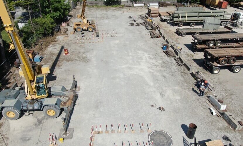 Aerial view of a construction site featuring trucks and heavy equipment working on the ground.